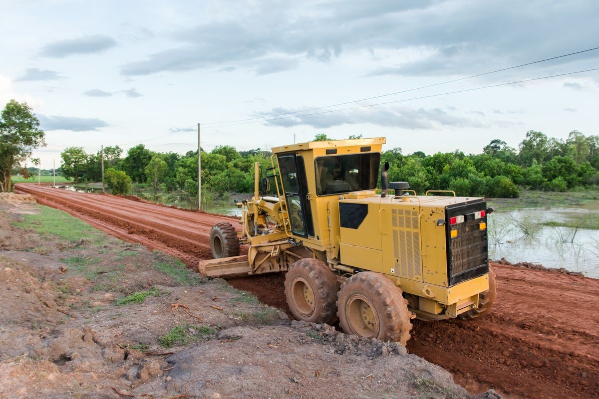 Yellow motor grader Road working on road construction site of new road. 